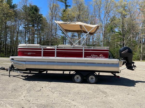 Sun Tracker Party Barge 22 RF DLX 2025 Sun Tracker Party Barge 22 RF DLX pontoon boat on trailer, parked outdoors.