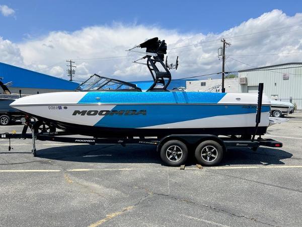Moomba Mojo 2018 Moomba Mojo™ boat on trailer, blue and white design, parked outdoors.