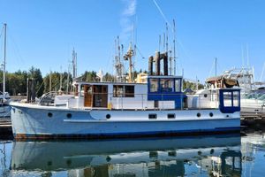 Custom Trawler 1956 Custom Trawler boat docked in a marina, reflecting on calm water.