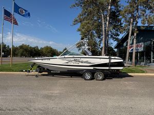 MasterCraft X-45 2007 MasterCraft X-45 boat on trailer, parked near flags and trees.