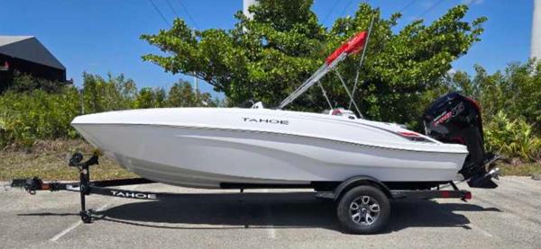 Tahoe T18 2025 Tahoe T18 boat on trailer, parked outdoors, surrounded by greenery.