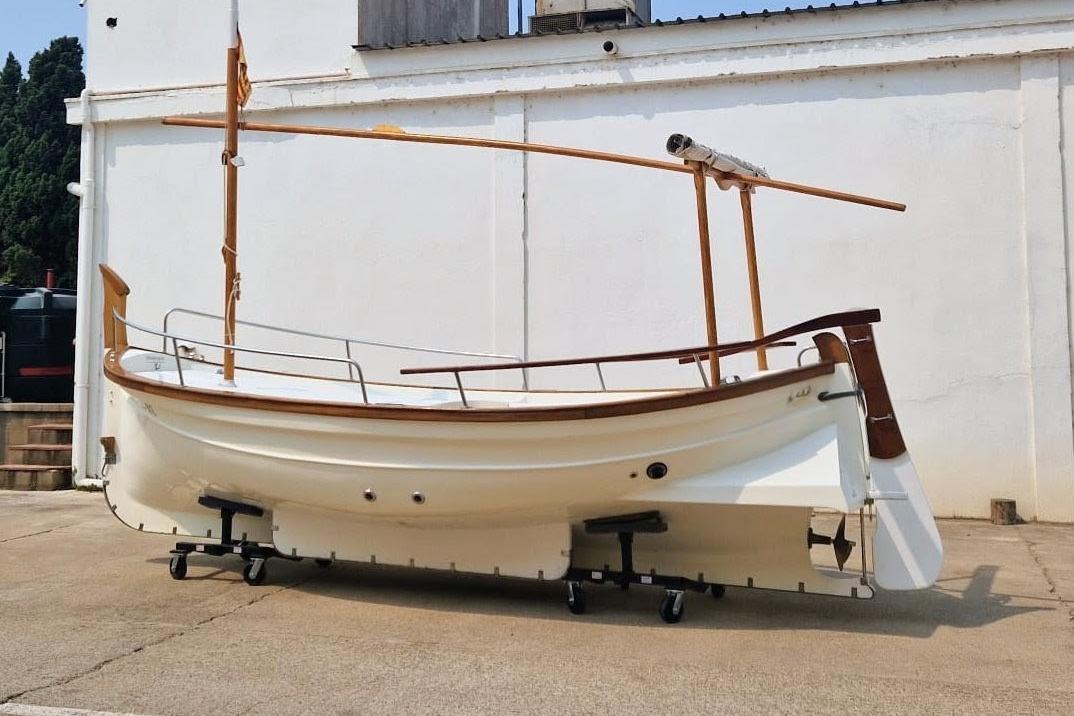 Menorquin 27 SOLARIUM 2011 Menorquin 27 SOLARIUM boat on display, white hull, wooden accents, outdoor setting.