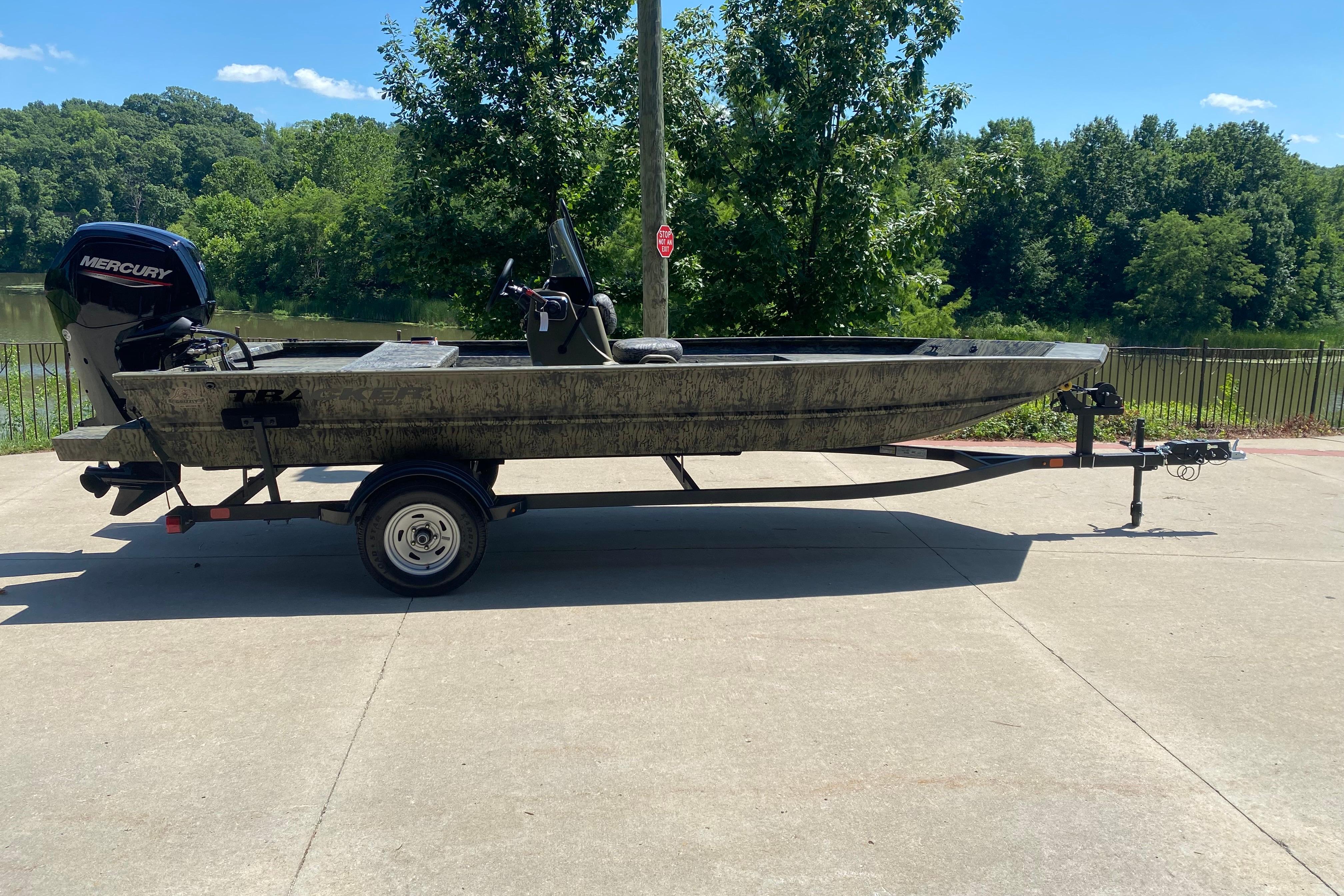 Tracker Grizzly 1860 CC 2026 Tracker Grizzly 1860 CC boat on trailer, parked outdoors near a lake.