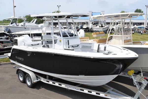 Blackfin 222CC 2024 Blackfin 222CC boat on trailer, sleek black and white design, outdoor display.