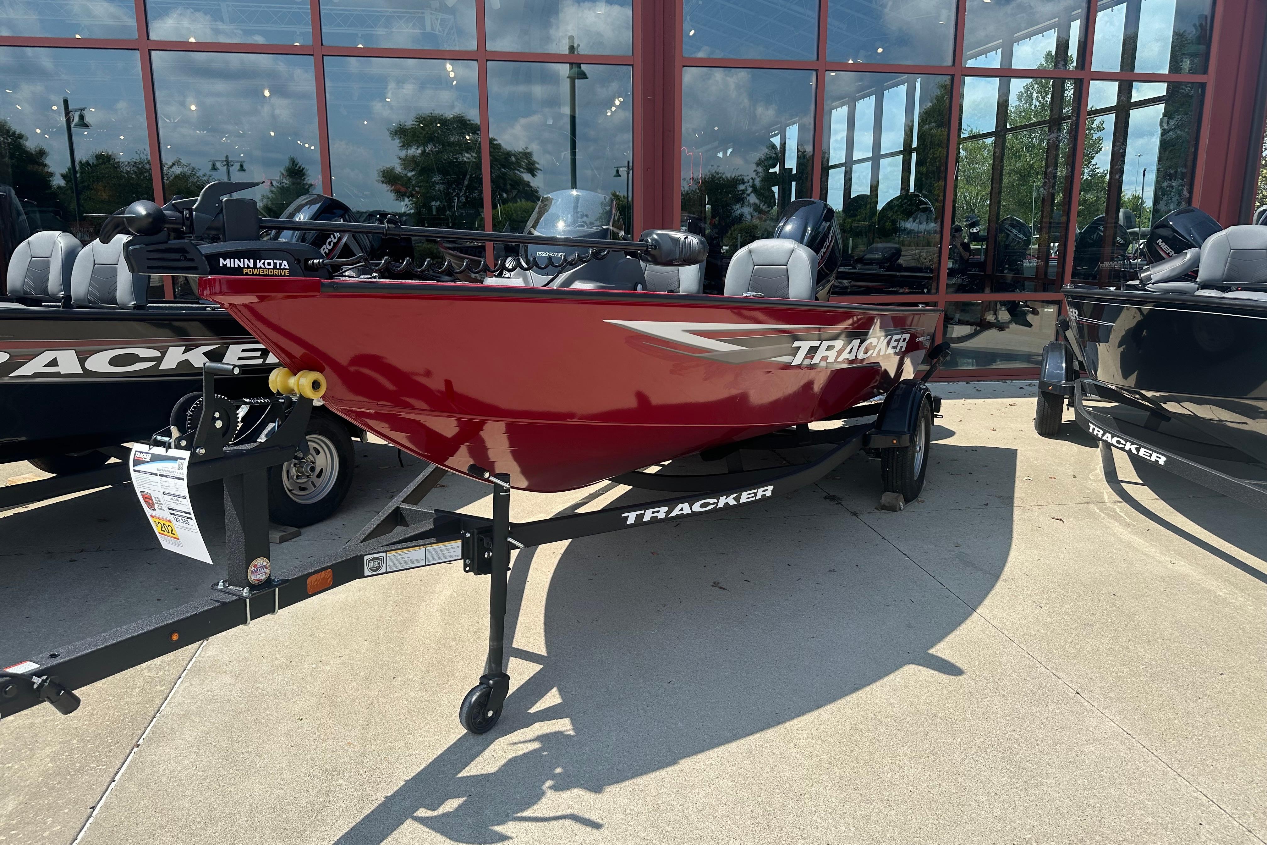 Tracker Super Guide V-16 SC 2026 Tracker Super Guide V-16 SC boat in red, displayed outdoors on a trailer.