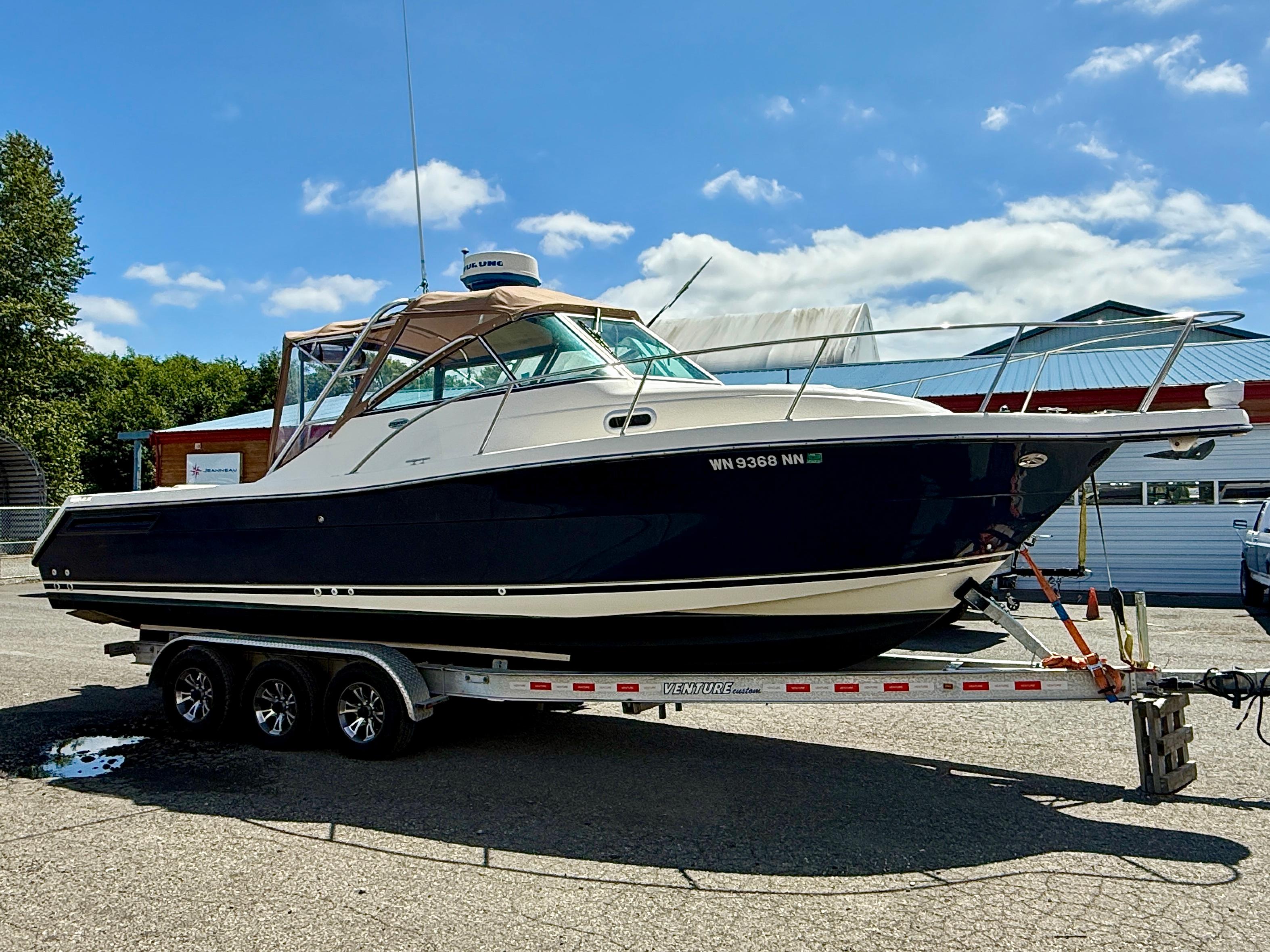 Pursuit 2865 Denali 2003 Pursuit 2865 Denali boat on trailer under clear blue sky.