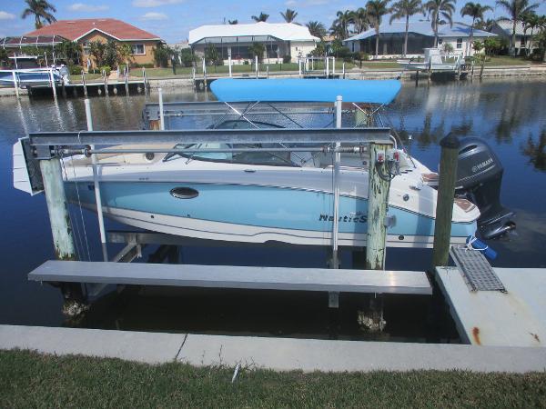 NauticStar 243DC Sport Deck 2018 NauticStar 243DC Sport Deck boat docked by waterfront homes.