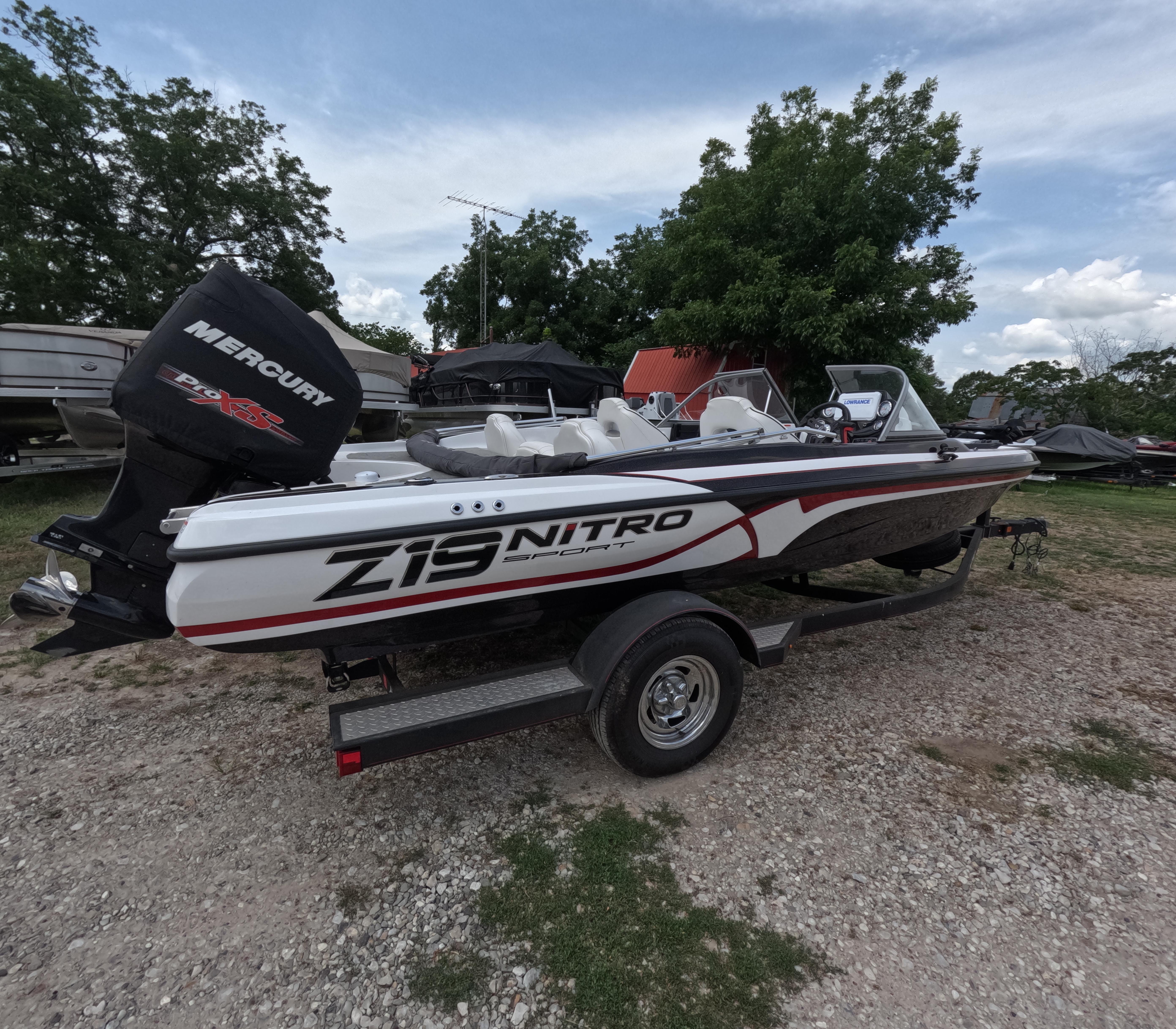 Nitro Z19 Sport 2018 Nitro Z19 Sport boat with Mercury engine on a trailer, parked outdoors.