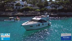 Princess 43 Luxurious 2014 Princess 43 yacht anchored in clear turquoise waters near a scenic coastline.