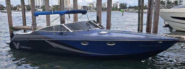 Formula 330 SS 2002 Formula 330 SS boat docked in a marina with cityscape background.