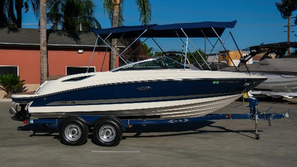 Sea Ray 210 SLX 2013 Sea Ray 210 SLX boat on trailer with blue canopy, parked outdoors.