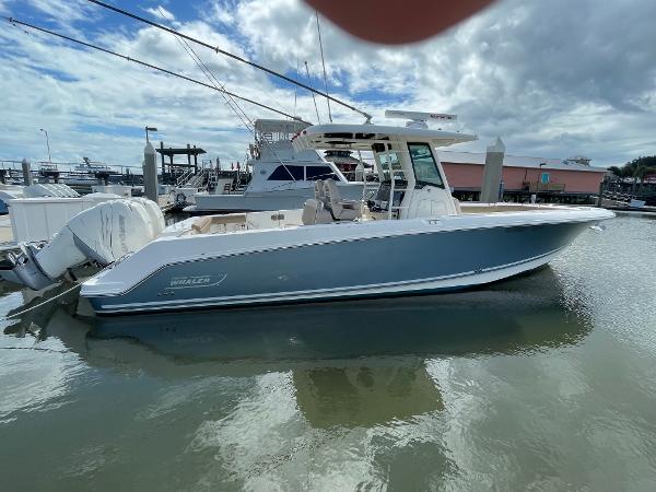 Boston Whaler 330 Outrage 2018 Boston Whaler 330 Outrage boat docked in marina under cloudy sky.