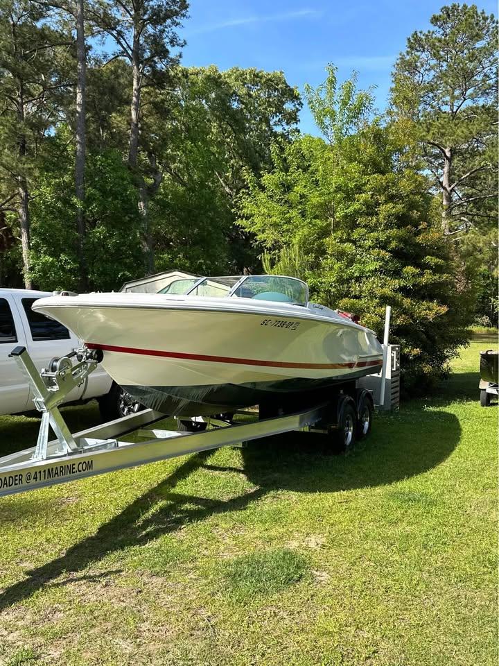 Chris-Craft Launch 22 2001 Chris-Craft Launch 22 boat on trailer, surrounded by trees and grass.