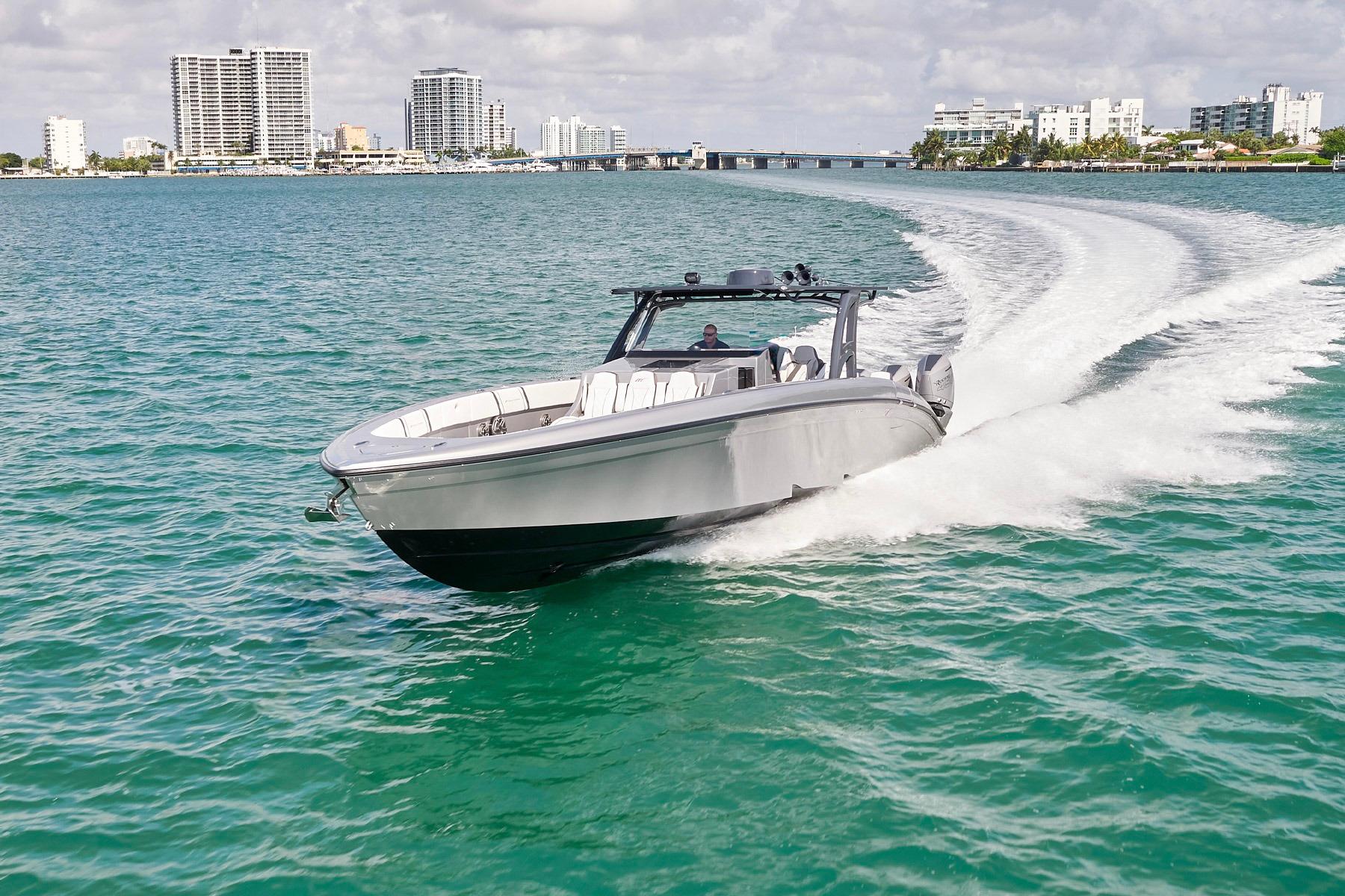 Midnight Express 43 Open 2022 Midnight Express 43 Open boat cruising on turquoise water near city skyline.