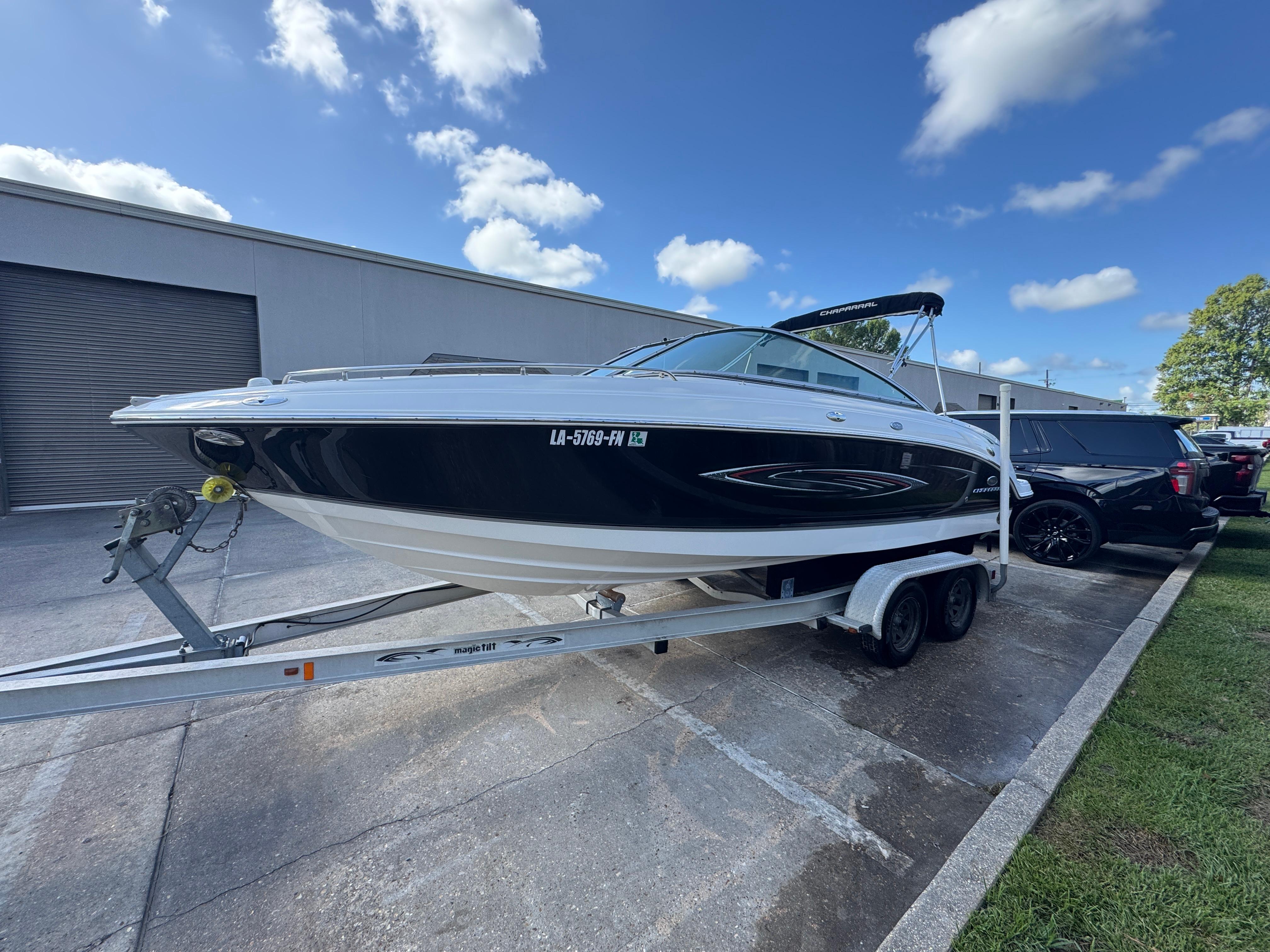 Chaparral 236 SSi 2006 Chaparral 236 SSi boat on trailer, parked outdoors under a blue sky.