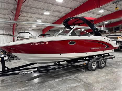 Chaparral 264 Sunesta 2009 Chaparral 264 Sunesta boat in a showroom, red and white exterior, on a trailer.