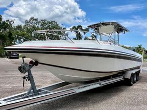 Fountain 31 Center Console 1994 Fountain 31 Center Console boat on trailer in parking lot, under blue sky.
