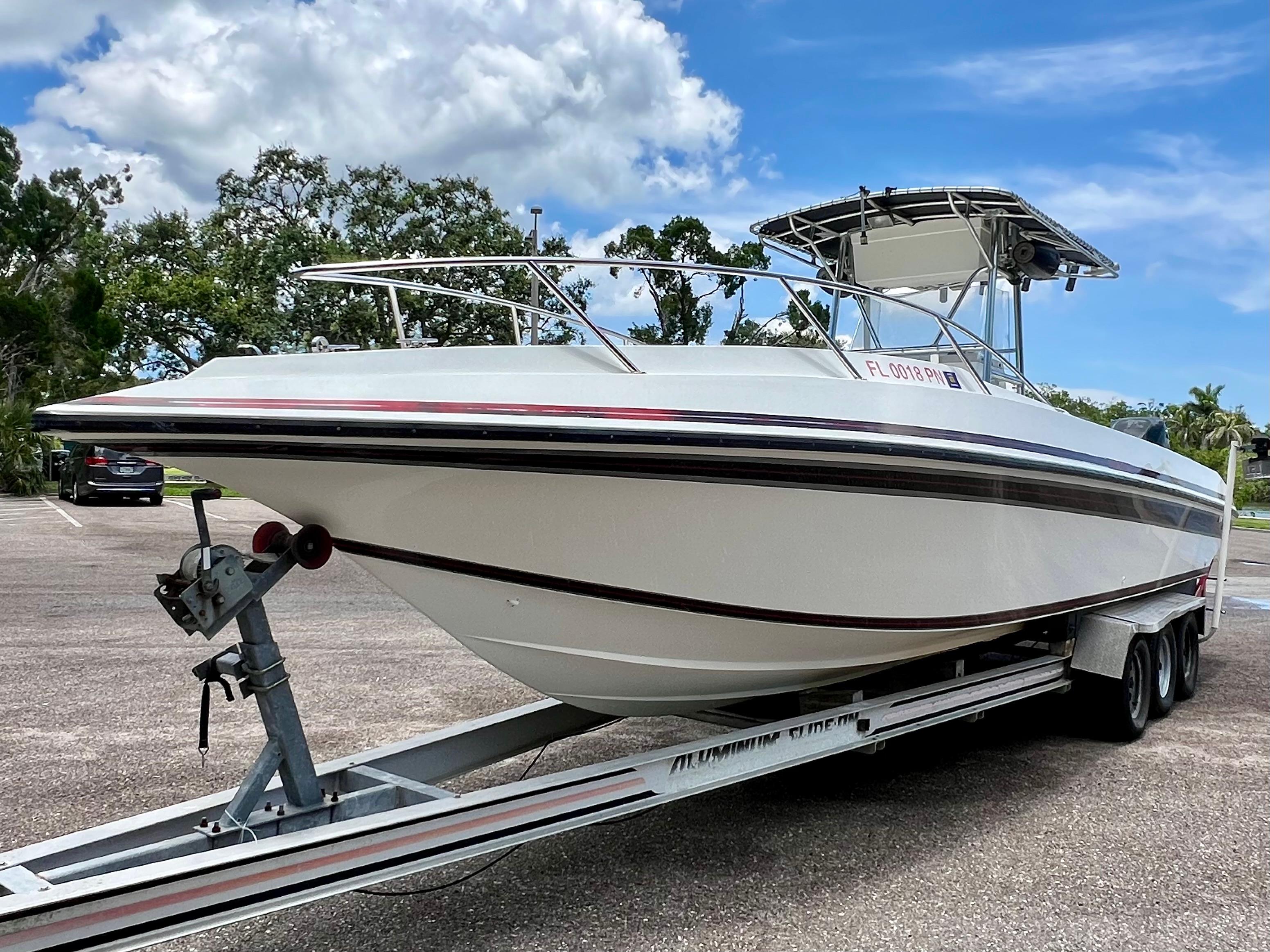 Fountain 31 Center Console 1994 Fountain 31 Center Console boat on trailer in parking lot, under blue sky.