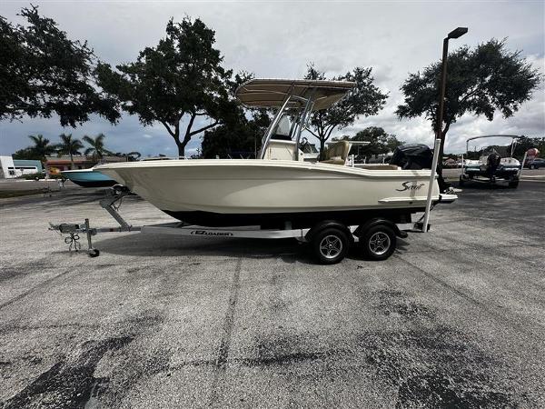 Scout 215 XSF 2021 Scout 215 XSF boat on trailer in parking lot, overcast sky.