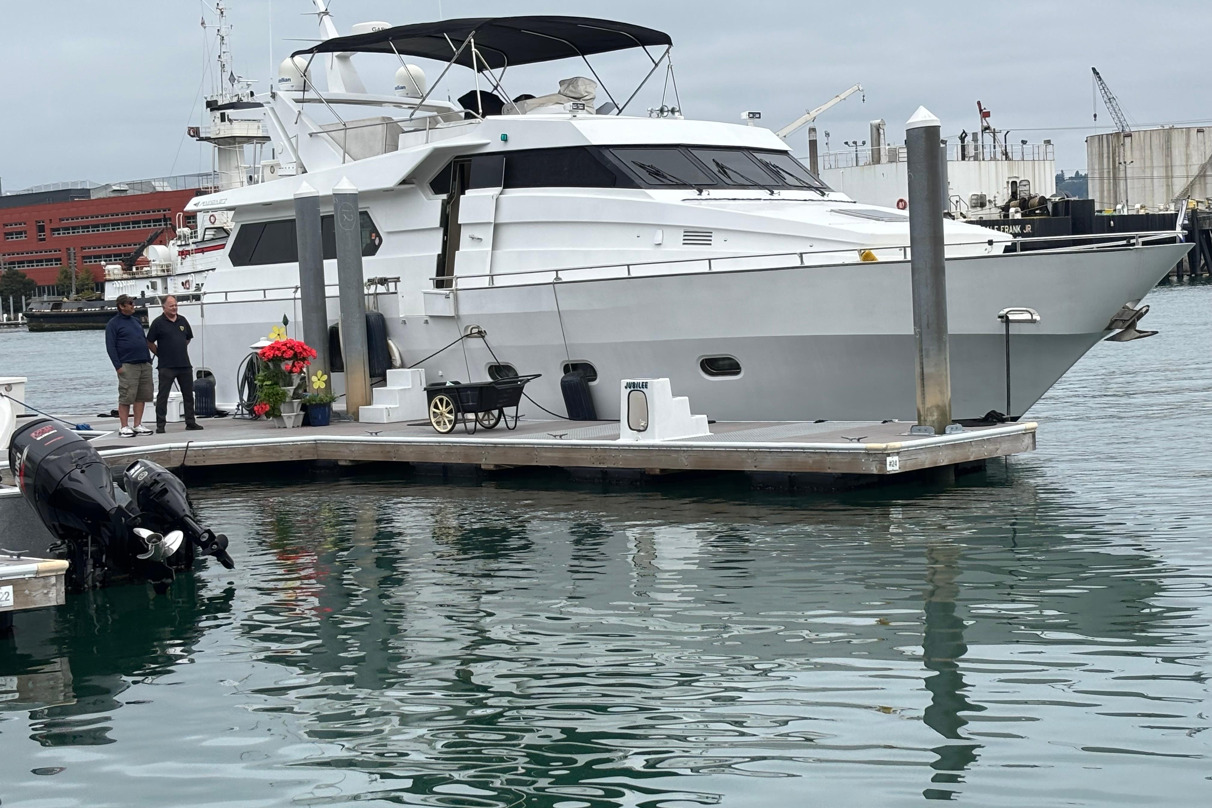 Maiora Phantom 1986 Maiora Phantom yacht docked at marina with people nearby, overcast sky.