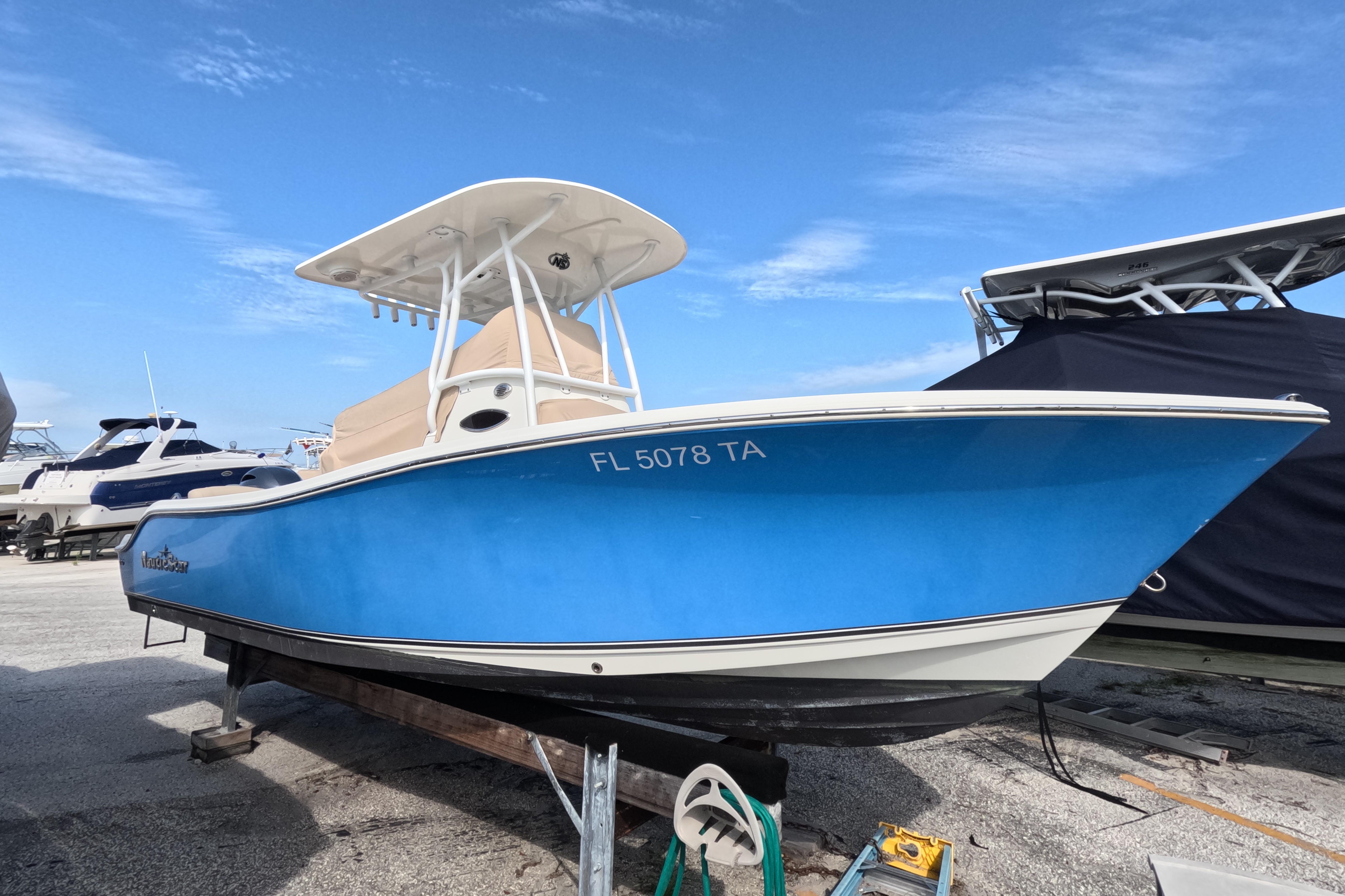 NauticStar 2302 Legacy 2017 NauticStar 2302 Legacy boat in blue, docked under a clear sky.