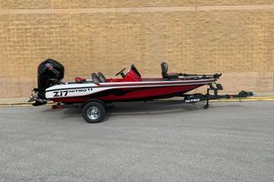 Nitro Z17 2026 Nitro Z17 boat with trailer, red and black design, parked against a brick wall.