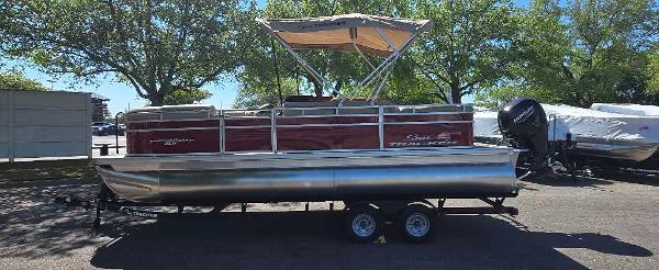 Sun Tracker Party Barge 22 RF DLX 2025 Sun Tracker Party Barge 22 RF DLX pontoon boat with canopy, parked on trailer.
