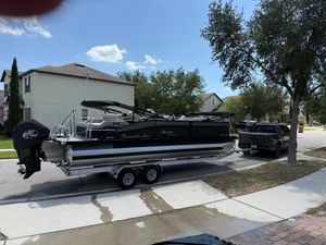 Barletta C24UC 2021 Barletta C24UC pontoon boat on trailer, parked in suburban neighborhood.