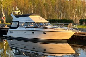Nord West 390 Flybridge Nord West 390 Flybridge 2002 yacht docked by a serene lakeside, reflecting in calm water.