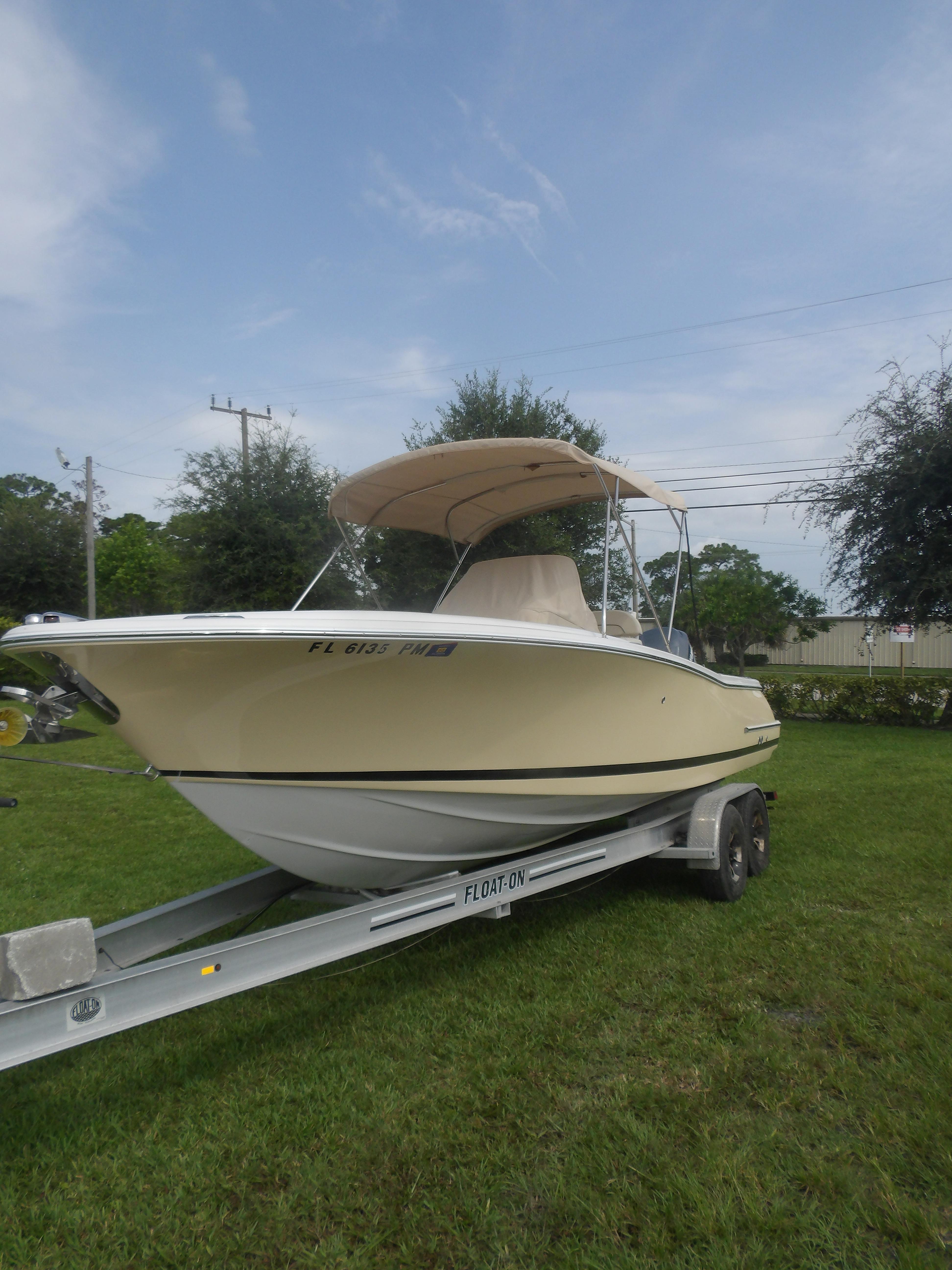 Chris-Craft Catalina 23 2008 Chris-Craft Catalina 23 boat on trailer, parked on grass.