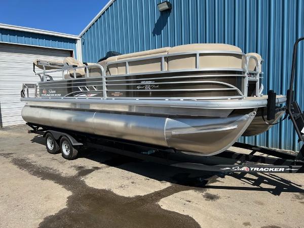 Sun Tracker SportFish™ 22 XP3 2023 Sun Tracker SportFish™ 22 XP3 pontoon boat on trailer outside blue building.