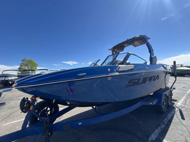 Supra SL 550 2024 Supra SL 550 blue boat on trailer under clear sky.