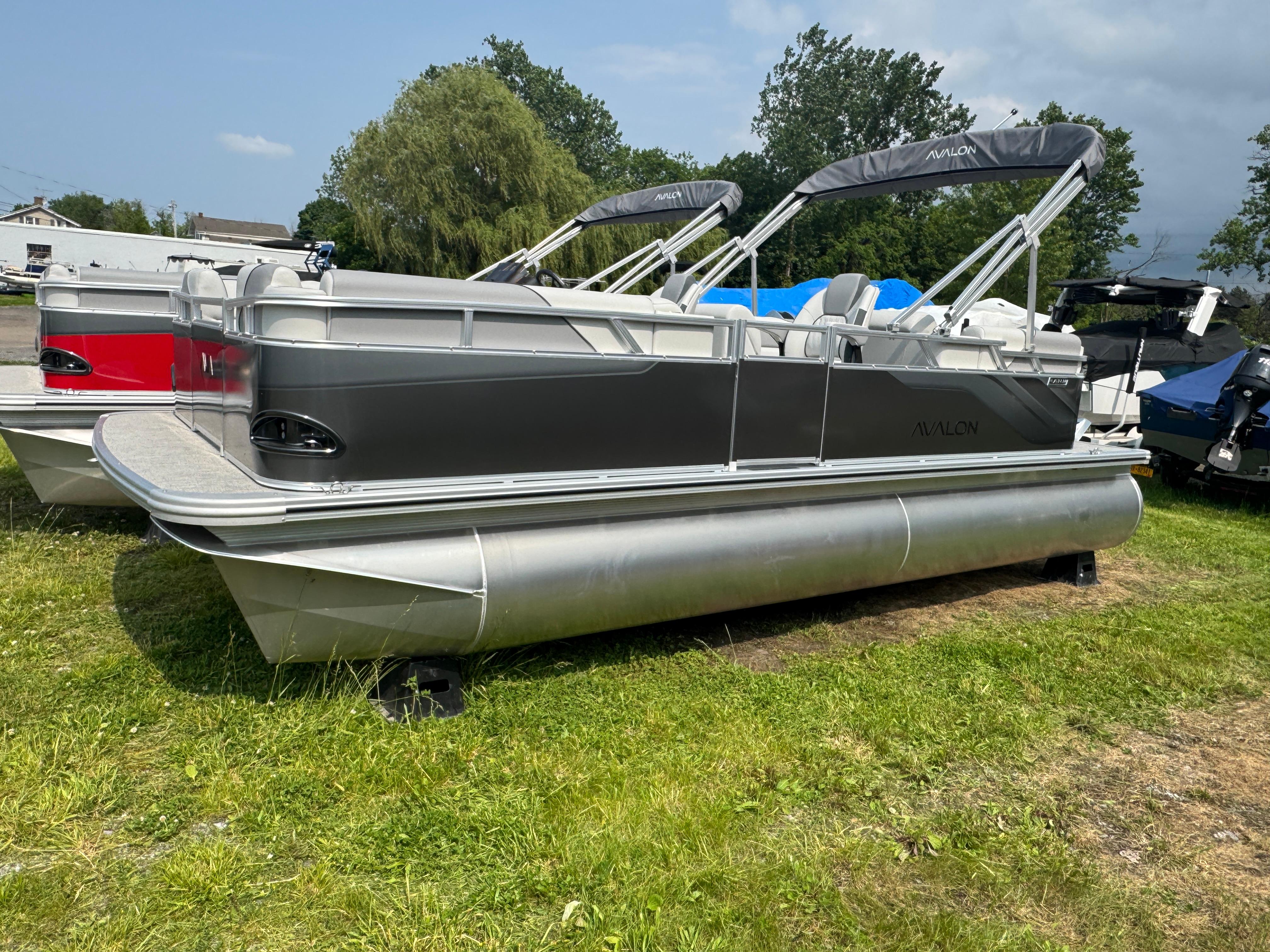 Avalon Venture QL 2025 Avalon Venture QL pontoon boat on grass, featuring sleek design and modern amenities.