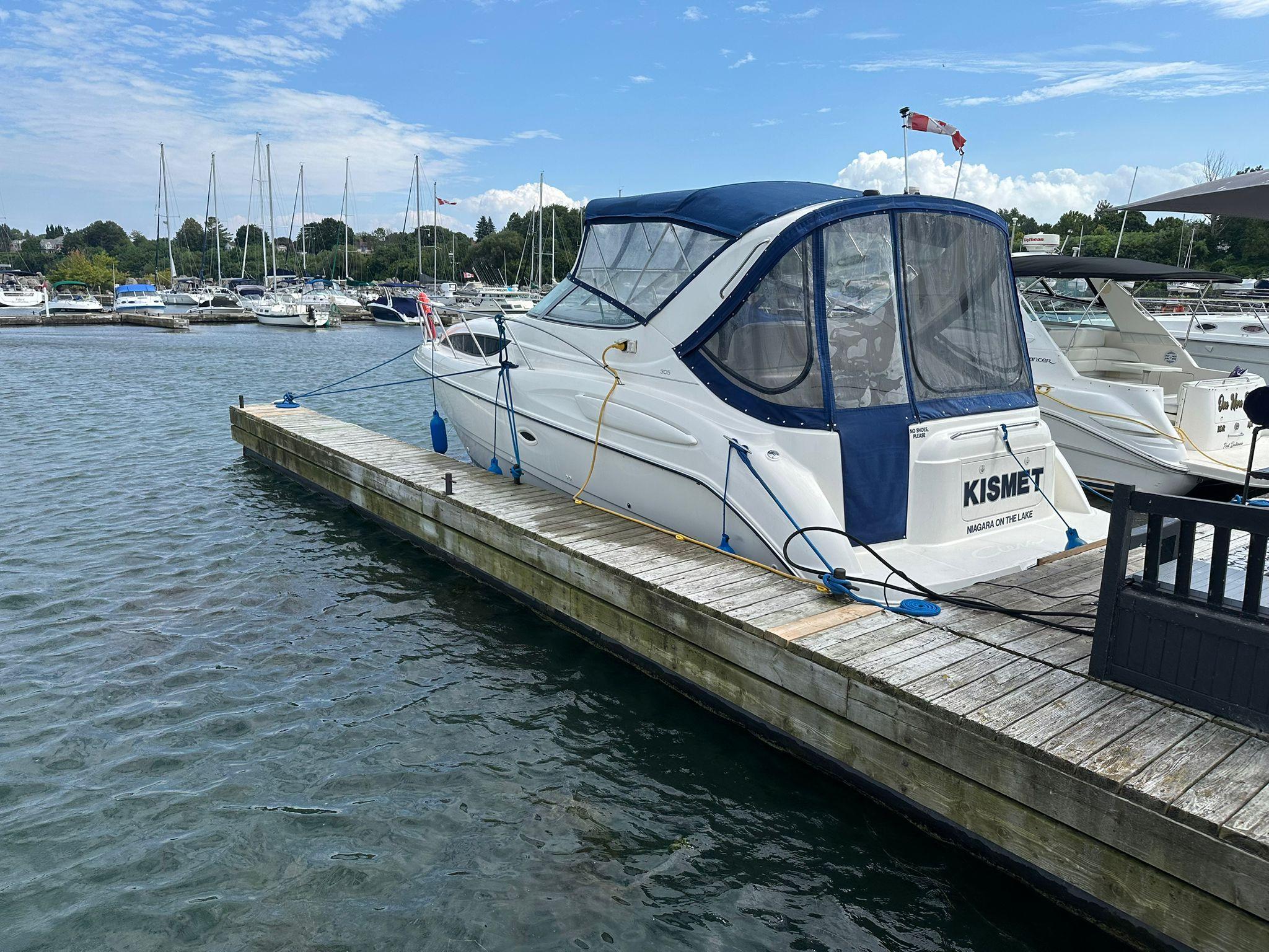 Bayliner 305 Ceira 2003 Bayliner 305 Ceira docked at marina with blue canopy and clear skies.