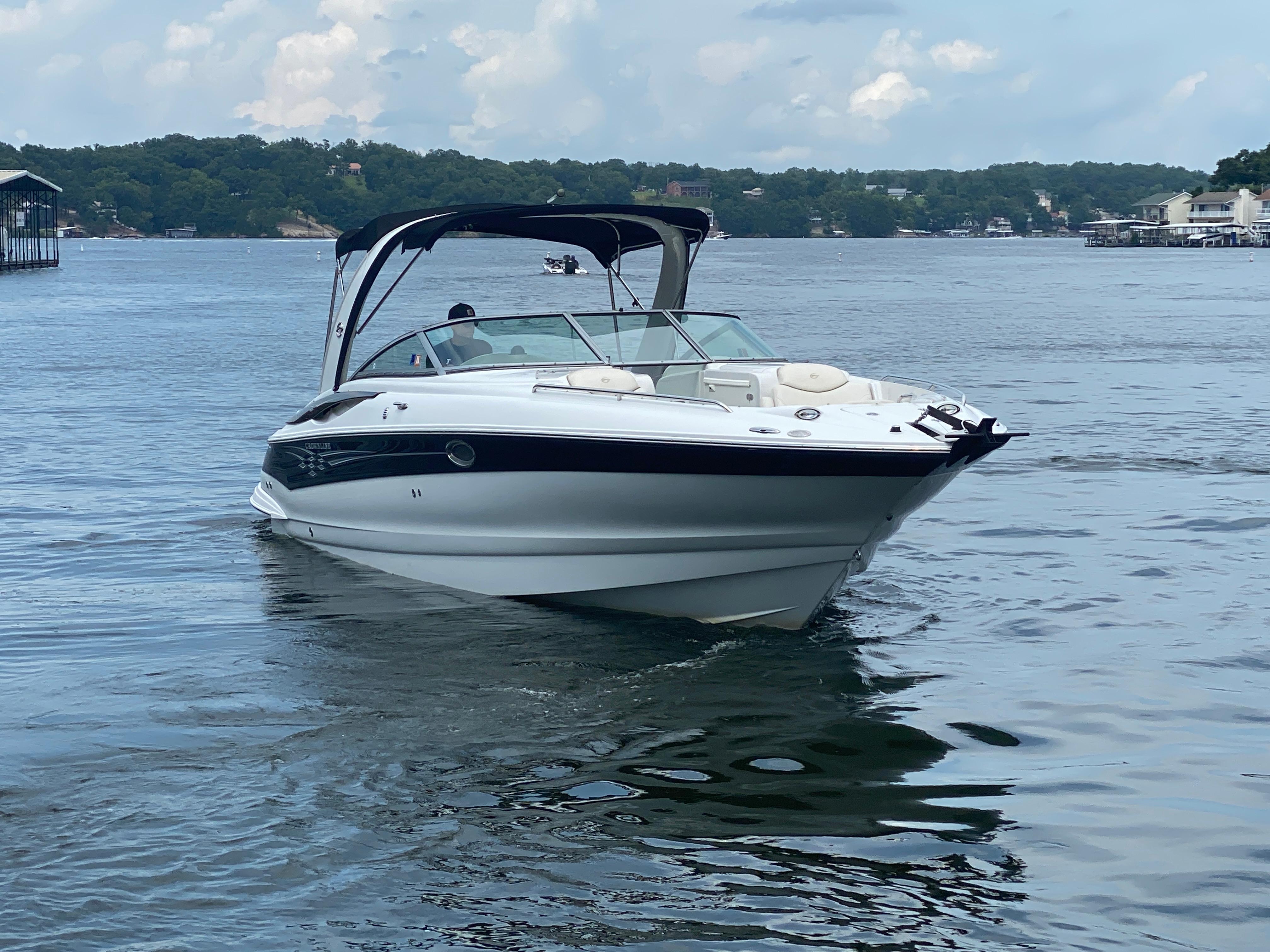 Crownline 320 LS 2006 Crownline 320 LS boat cruising on a serene lake with lush green shoreline.
