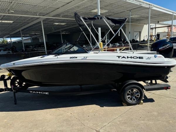 Tahoe 200 S 2025 Tahoe 200 S boat with black hull and canopy, parked on a trailer.