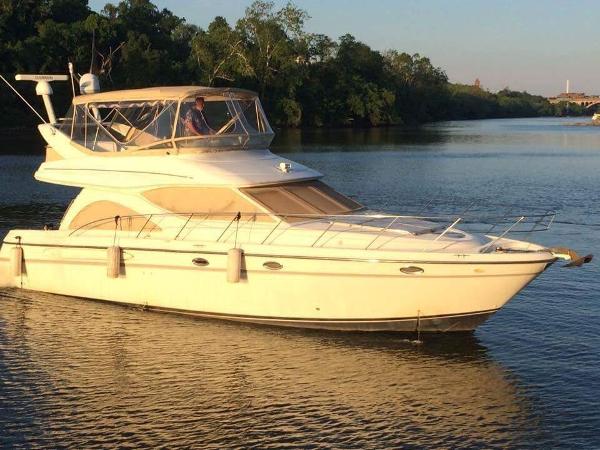 Maxum 4600 SCB 2000 Maxum 4600 SCB yacht cruising on a calm river at sunset.