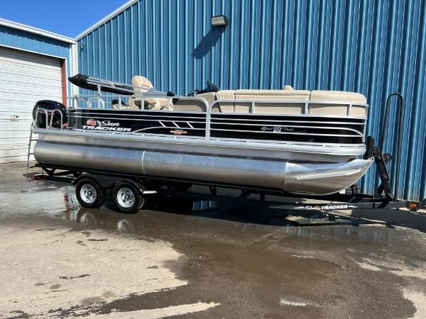 Sun Tracker Sportfish™ 20 DLX 2023 Sun Tracker Sportfish™ 20 DLX pontoon boat on trailer outside blue building.