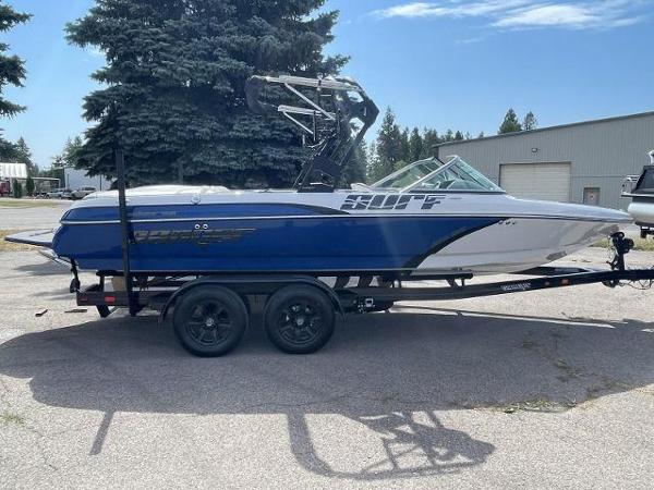 Sanger V215 SX 2023 Sanger V215 SX boat on trailer, blue and white, parked outdoors.