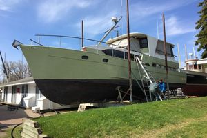 Custom 51 1970 Custom 51 boat on land, undergoing maintenance under clear blue sky.