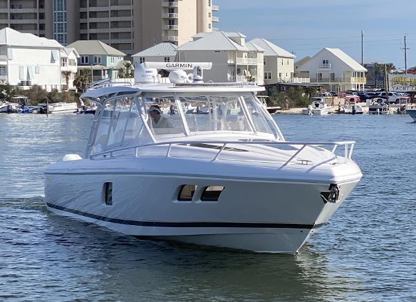 Intrepid 407 Cuddy 2020 Intrepid 407 Cuddy boat cruising in a marina with waterfront buildings.