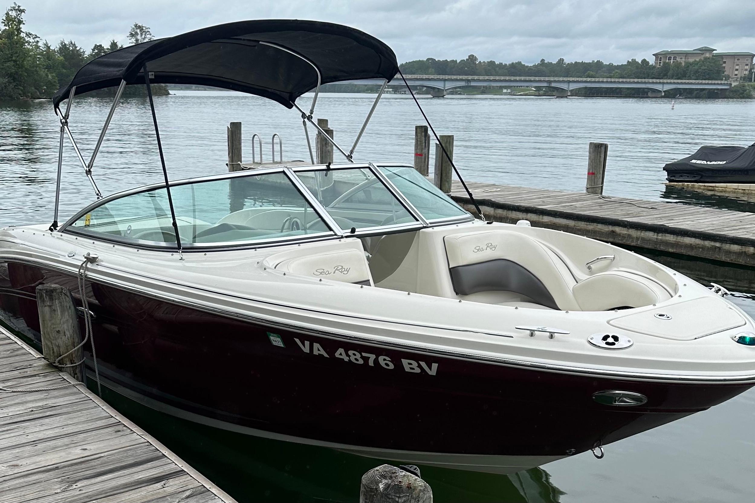 Sea Ray 220 Select 2006 Sea Ray 220 Select boat docked by a serene lake with a bridge view.