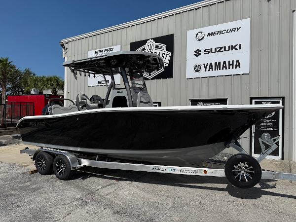 Sea Pro 245 Sandbar 2025 Sea Pro 245 Sandbar boat on trailer, parked outside dealership with brand logos.