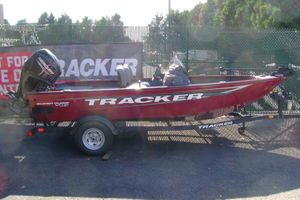 Tracker Super Guide V-16 SC 2026 Tracker Super Guide V-16 SC boat on trailer, red color, parked outdoors.