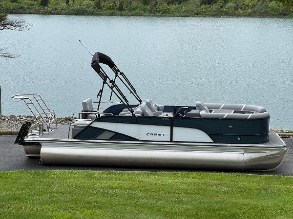 Crest Classic 220 SLRC 2025 Crest Classic 220 SLRC pontoon boat by a serene lake.