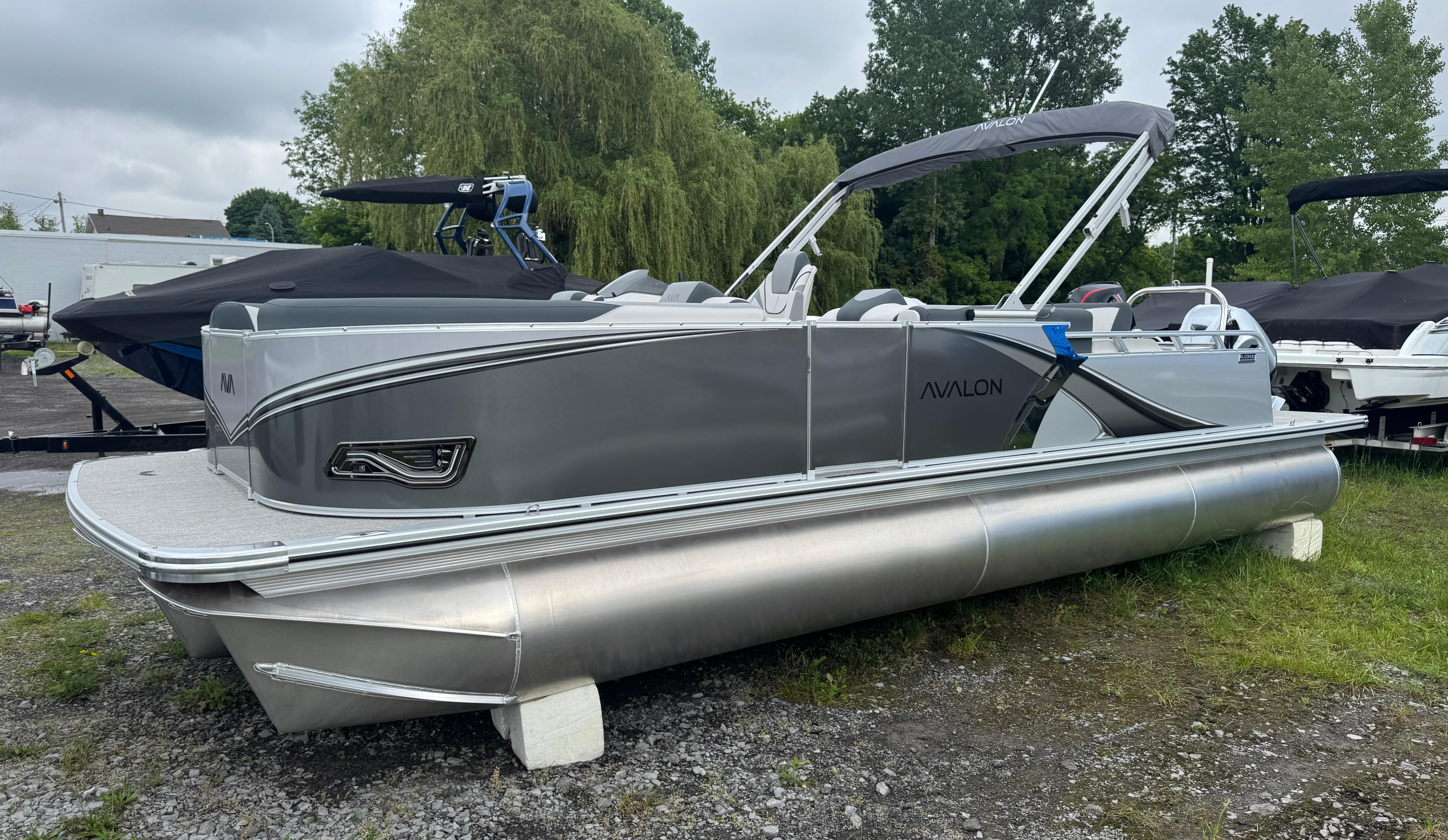 Avalon LSZ VRB 2025 Avalon LSZ VRB pontoon boat in a grassy outdoor setting.