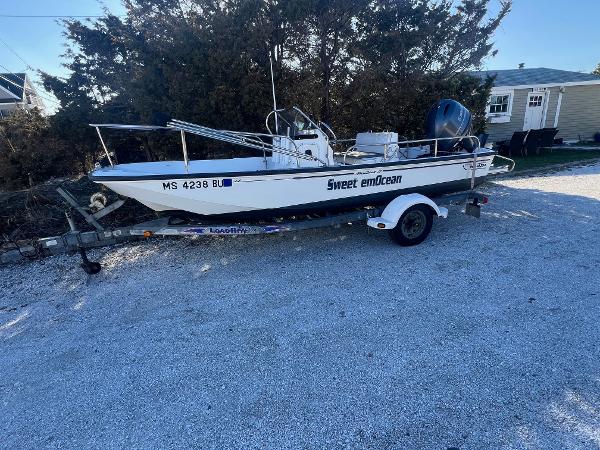 Boston Whaler 17 Montauk 2000 Boston Whaler 17 Montauk boat on trailer, labeled "Sweet emOcean," parked on gravel.