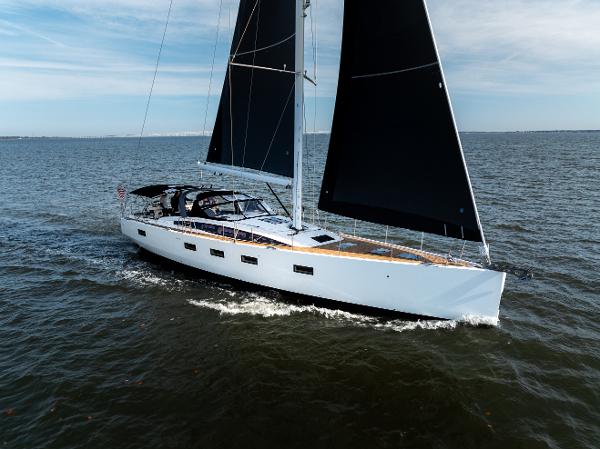 Jeanneau 64 Sailing yacht Jeanneau 64, 2016 model, cruising on open water with black sails.