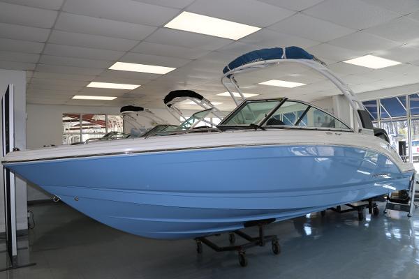 Chaparral 23 SSi OB 2024 Chaparral 23 SSi OB boat in showroom, featuring sleek blue hull design.