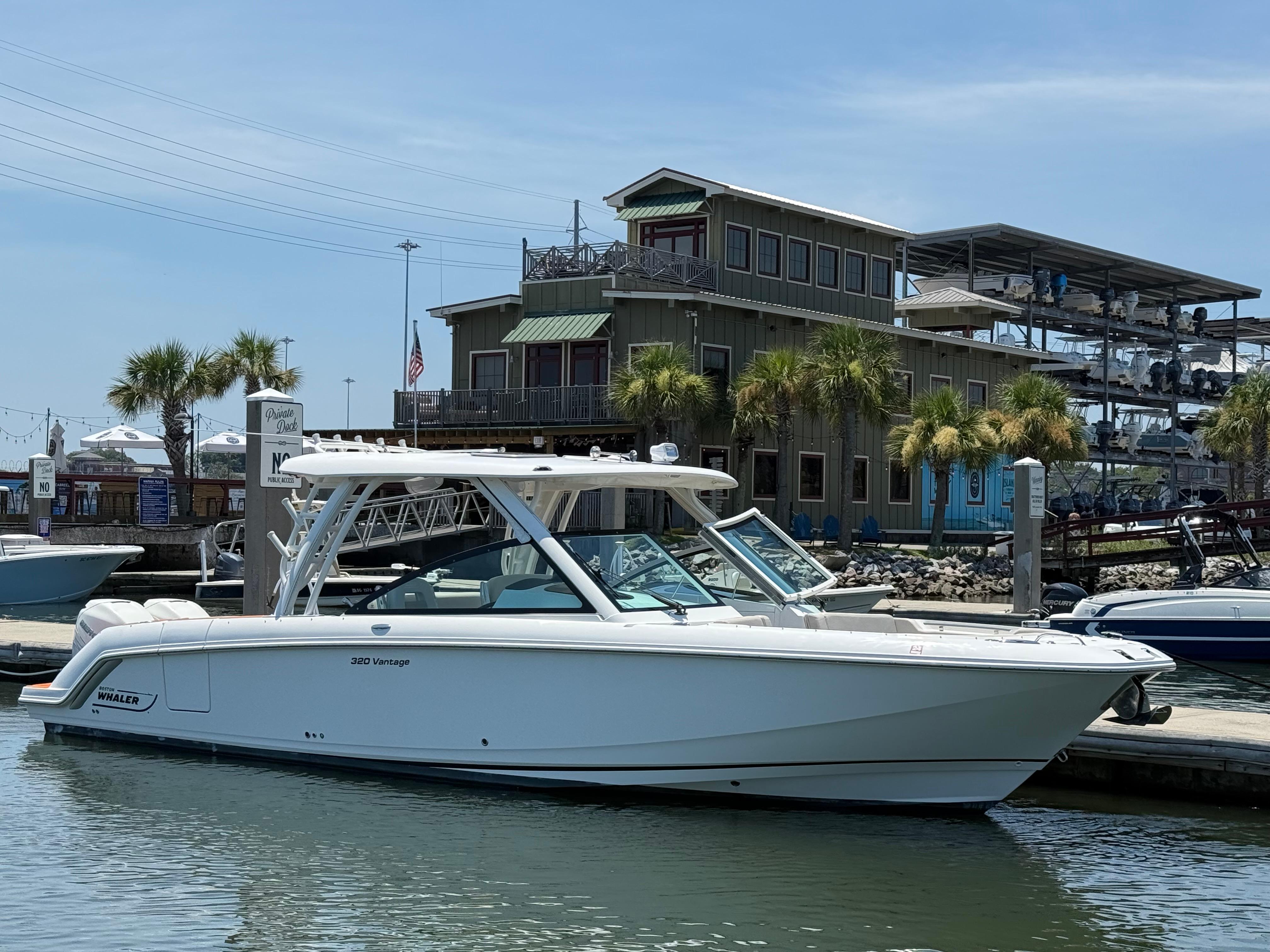 Boston Whaler 320 Vantage 2019 Boston Whaler 320 Vantage boat docked at marina with palm trees and building.